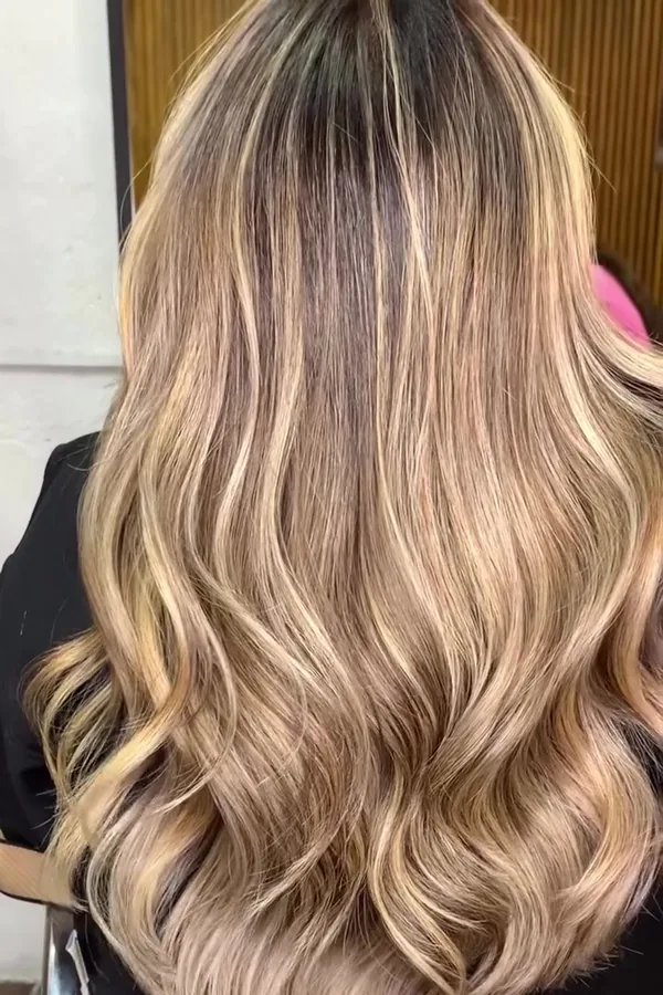 Después: cabello largo rubio con balayage y ondas, vista de espalda